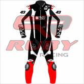 Front-facing image of Jack Miller's Yamaha MotoGP 2025 test suit in black, white, and red, showing sponsor patches from Quad Lock and CAT, number 43 on chest and legs, Ruby Racing on collar, and armored knees ā pro-grade racing suit.